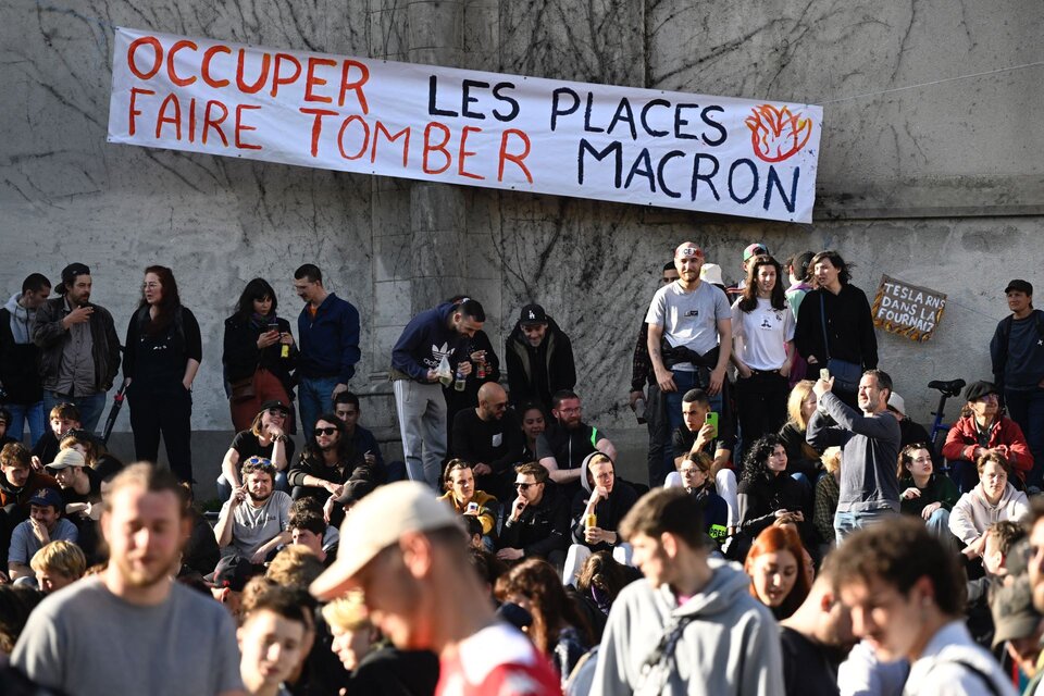 "Ocupar los lugares,  derribar a Macron", reza el cartél desplegado en un edificio público en París. (Foto: AFP)