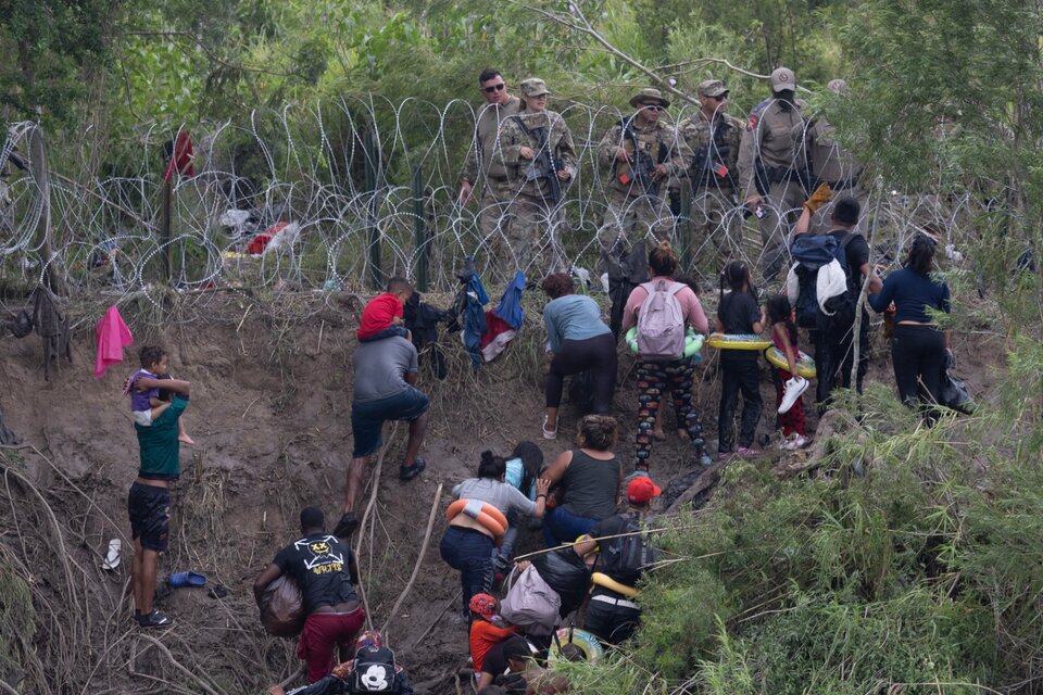 Imigrantes enfrentan a guadrias fronterizos de EE.UU. tras cruzar el Río Grande en Matamoros, México. (Fuente: AFP)