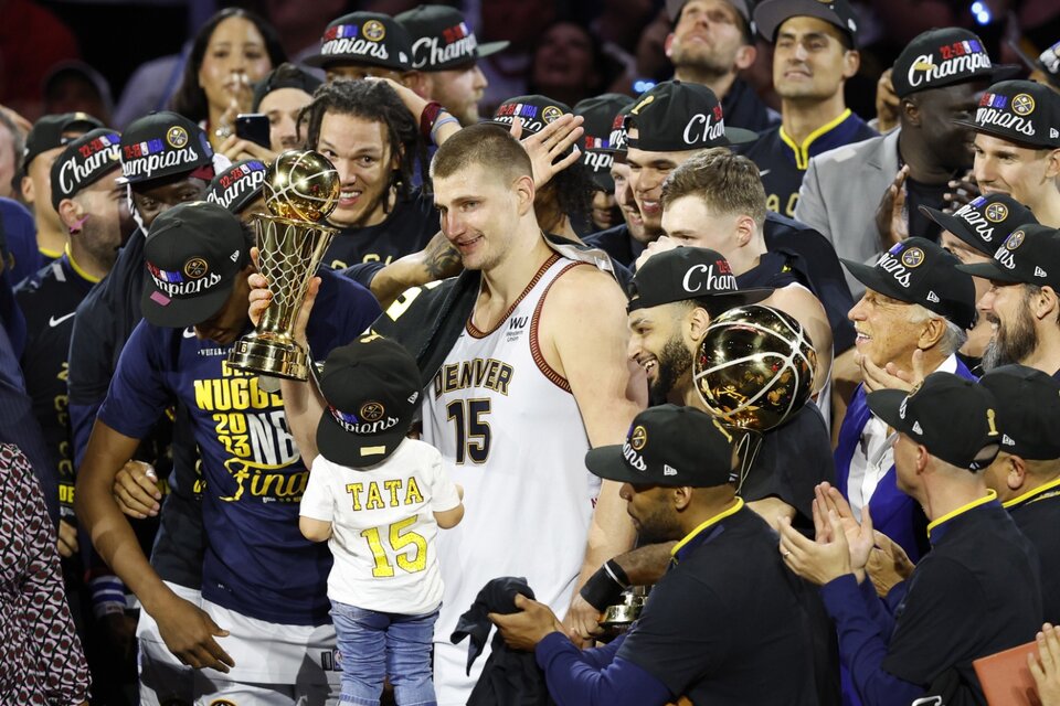 Nikola Jokic levanta el trofeo al MVP de las Finales, junto a su hija. Es recién el quinto no estadounidense en ganarlo. (Fuente: EFE)
