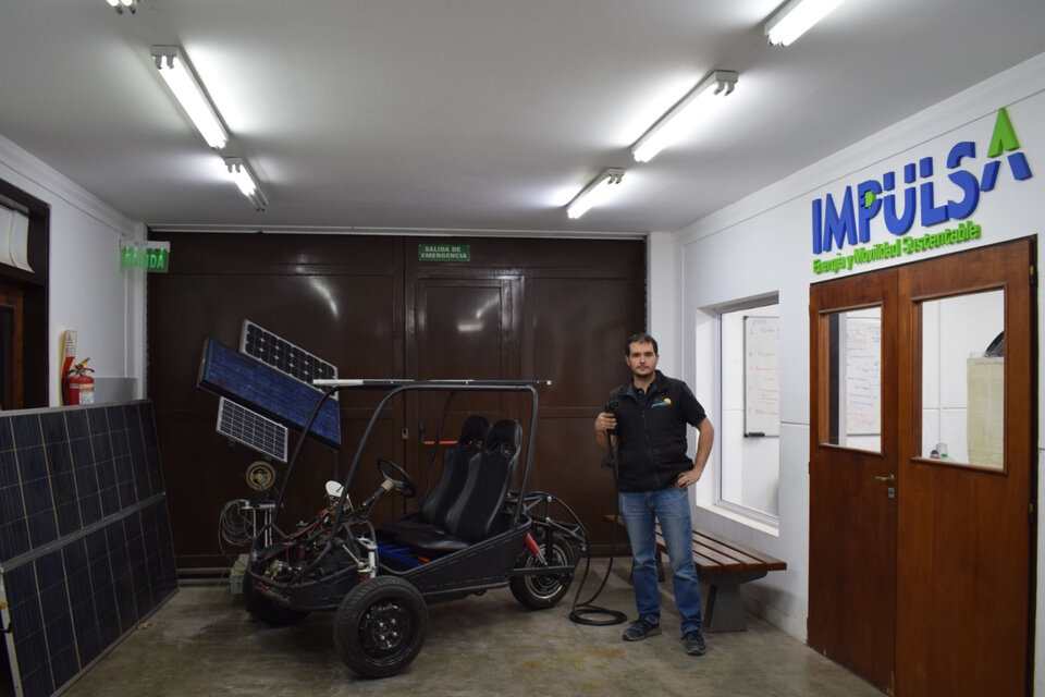 Nicolás Brizzio posa junto al vehículo biplaza en el Laboratorio de Electromovilidad. (Fuente: FIO-UNICEN)