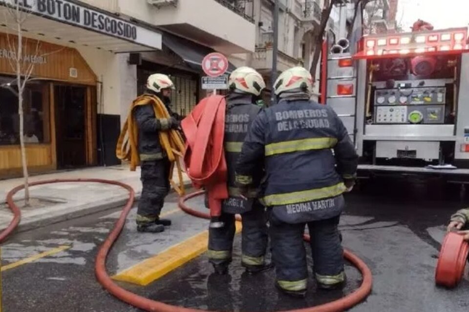 Los bomberos en la entrada del edificio que se incendió. 