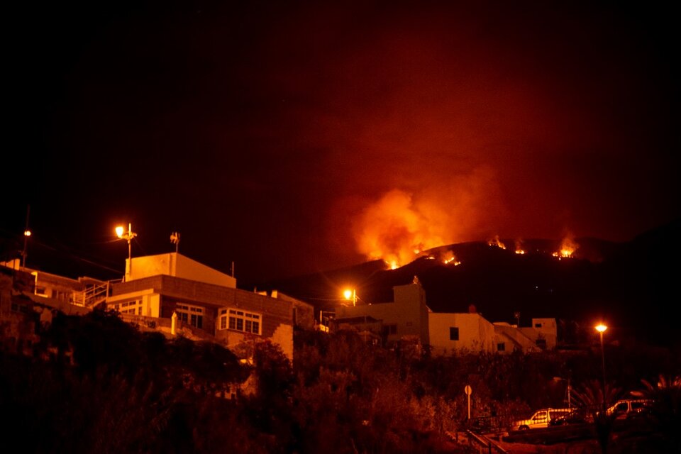 El fuego se expande en las colinas por encima de las casas, en el valle de Guimar en la isla canaria de Tenerife. (Fuente: AFP)