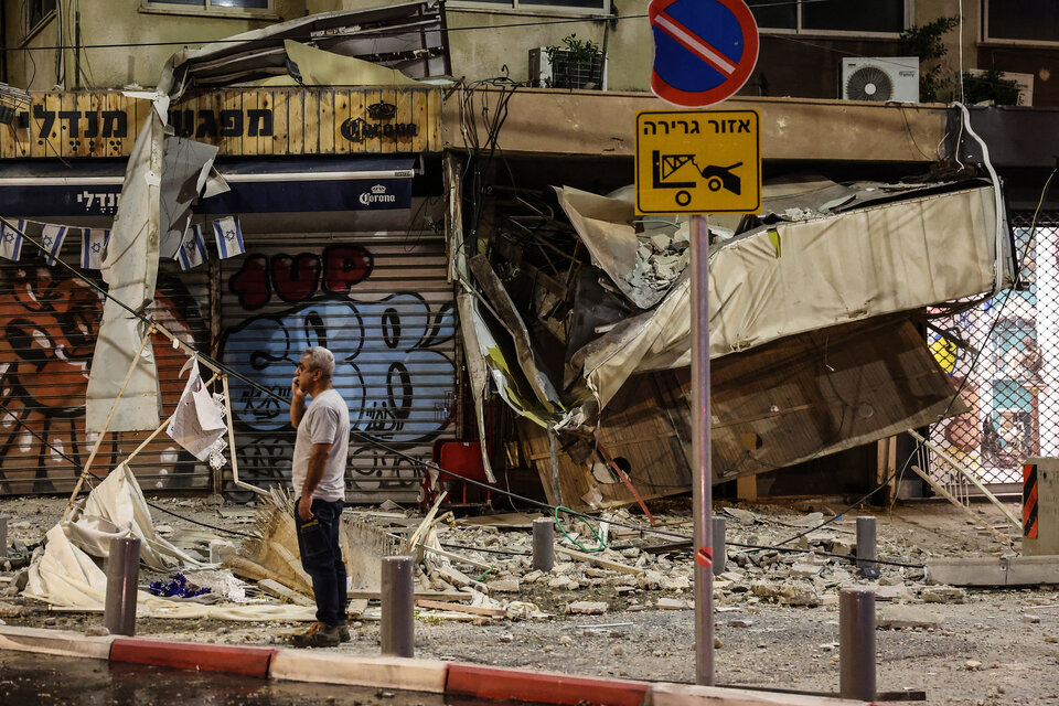 Un hombre se para frente a un negocio bombardeado en Tel Aviv. (Fuente: AFP)