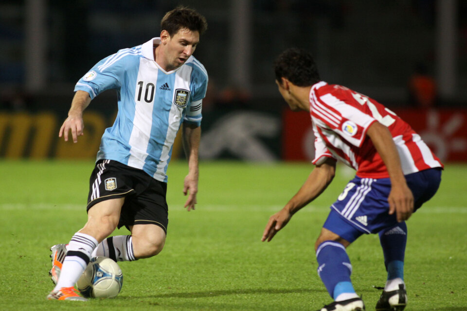 Messi va para su zurda y el rival para el otro lado. Estampa inmortal, durante el último triunfo de Argentina como local de Paraguay, en 2012 (Fuente: NA)