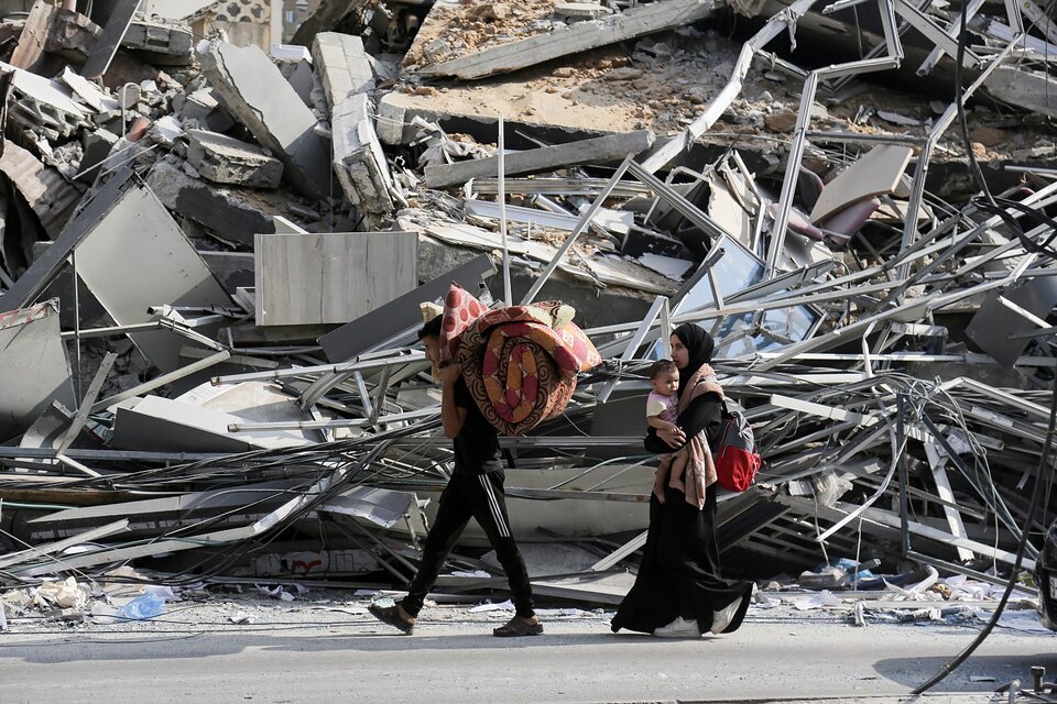 Una familia abandona una Cuidad de Gaza en ruinas con lo que puede cargar. (Fuente: EFE)