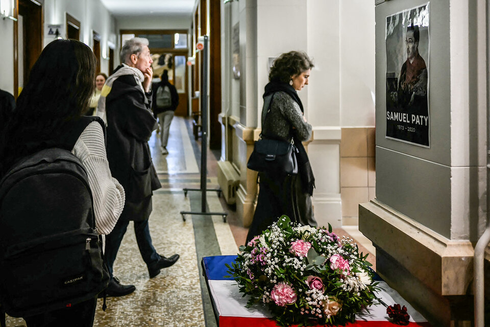 Estudiantes y profesores pasan frente al retrato del profesor asesinado. (Fuente: AFP)