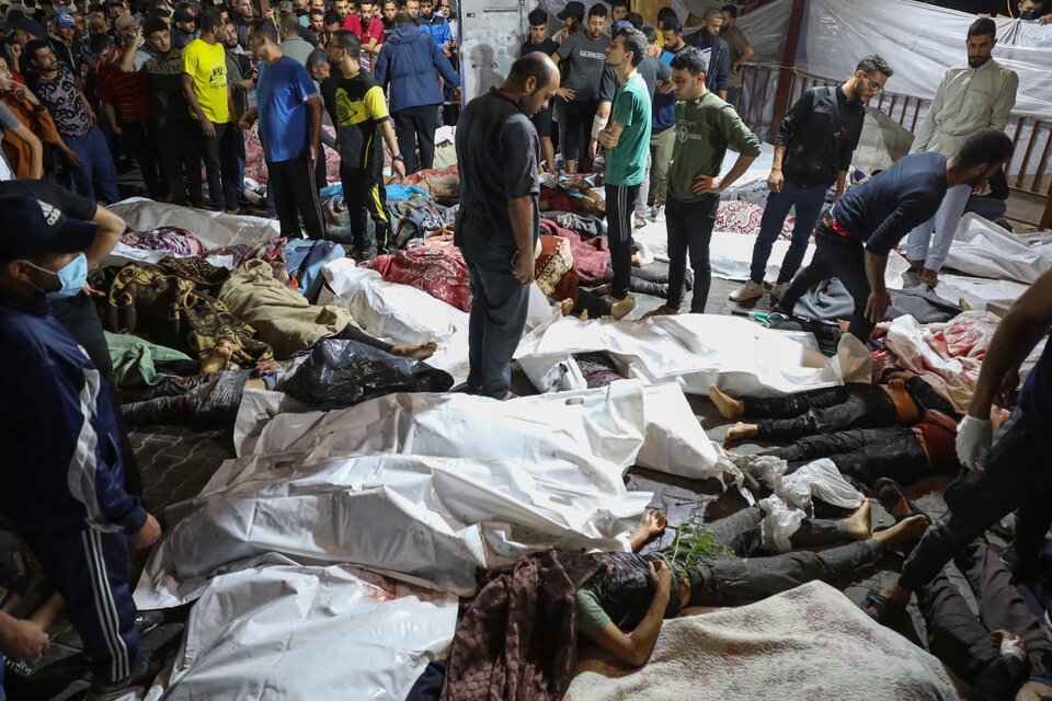 Palestinos rodean cadáveres de lasvíctimas delbombardeo al hospital. (Fuente: AFP)