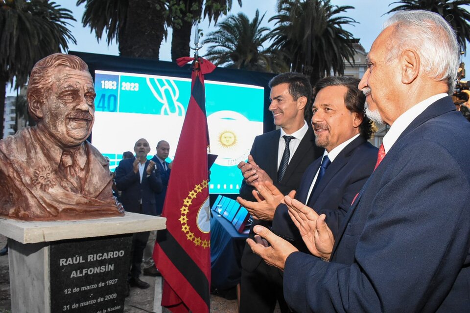 Urtubey, Sáenz y Romero frente al busto de Raúl Alfonsín. 
