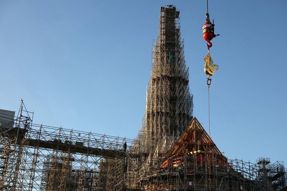 El nuevo gallo dorado con reliquias es izado por una grúa para ser instalado en lo alto de la aguja de la catedral de Notre Dame. (Fuente: AFP)