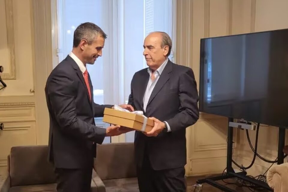 El ministro del Interior, Guillermo Francos (der.), le entrega al titular de la Cámara de Diputados, Martín Menem, el paquete con más de 300 hojas denominado "Ley de Bases y Puntos de Partida para la Libertad de los Argentinos". 