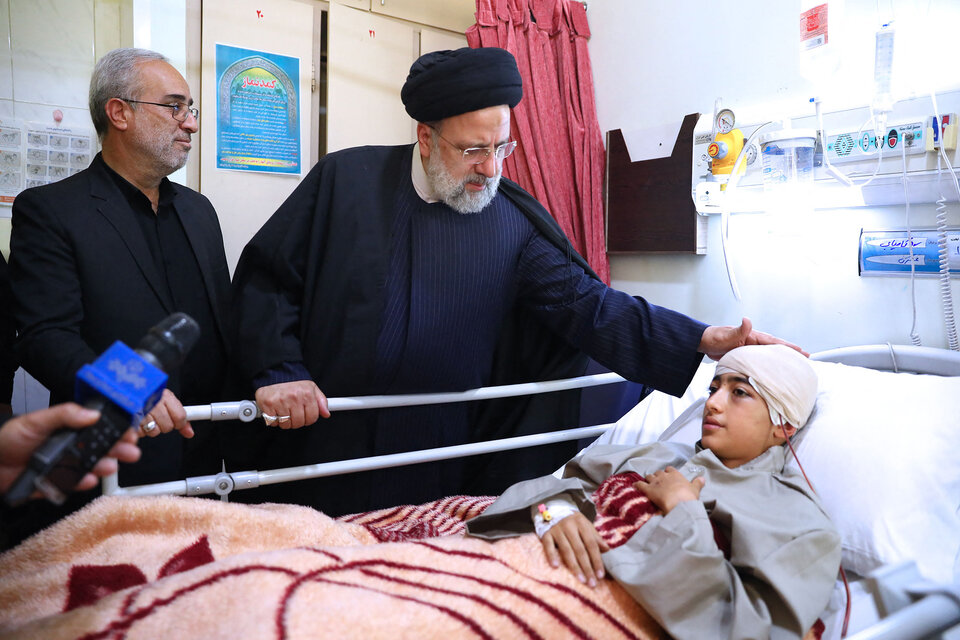 El Presidente Irán, Ebrahim Raisi, junto a un herido en atentado.  (Fuente: AFP)
