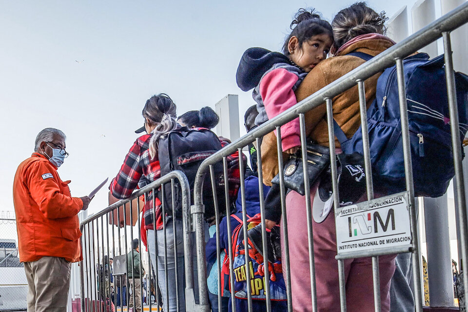 Migrantes hacen fila para solicitar un proceso de asilo en EE.UU. en el paso fronterizo de Baja California, México. (Fuente: EFE)