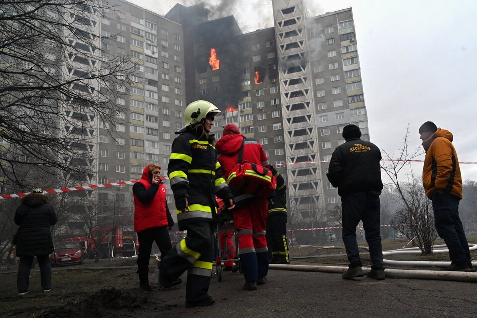 Rescatistas y bomberos en un edificio incendiado por un bombardeo ruso en Kiev. (Fuente: AFP)