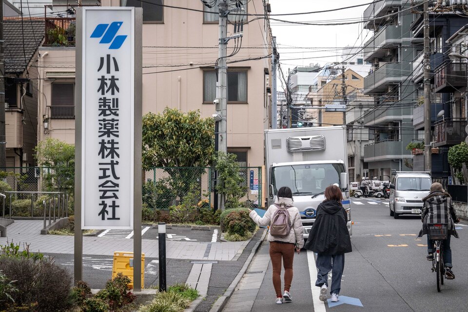 Una mujer señala con el dedo el cartel de Kobayashi Pharmaceutical mientras pasa por delante de la oficina de la empresa en Tokio el 28 de marzo de 2024.  (Fuente: AFP)