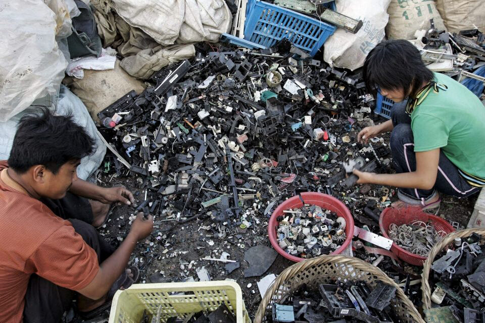 Unos trabajadores chinos desmontan ordenadores en la basura electrónica de Guiyu en la provincia de Guangdong en China.  (Fuente: EFE)
