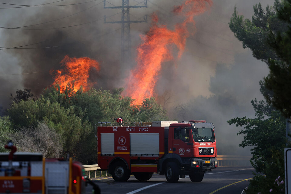 Bomberos israelíes apagan un incendio causado por un ataque de Hezbolá en Galilea. (Fuente: EFE)