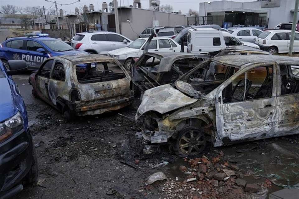 Los vehículos quemados en el entorno desordenado de la comisaría.