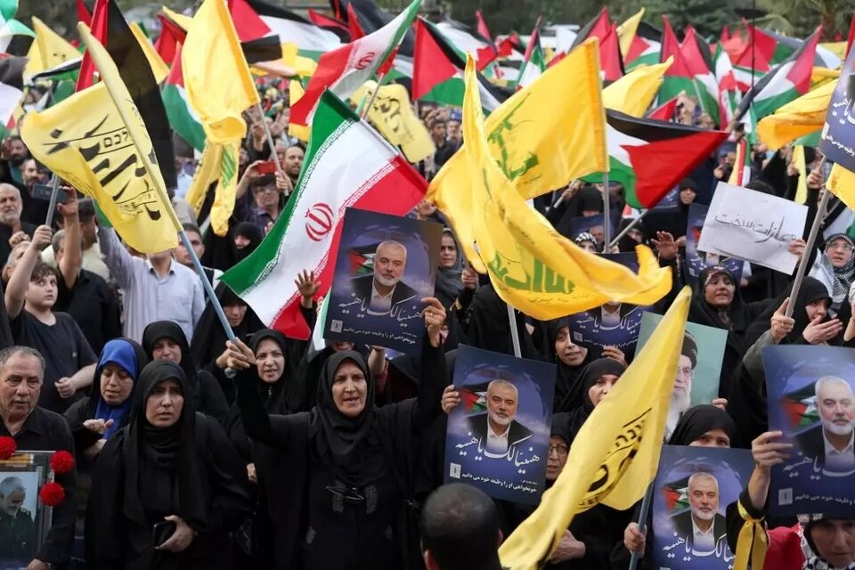 Iraníes sostienen una imagen del fallecido líder de Hamas, Ismail Haniyeh, y banderas palestinas y de Hezbollah durante una protesta en la Plaza de Palestina en Teherán, Irán, el 31 de julio de 2024. (Fuente: EFE)