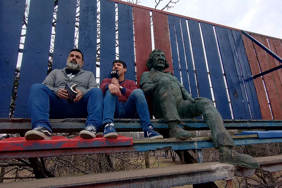 Ariel Gómez y Facundo Paredes junto a la estatua del Trinche Carlovich. 