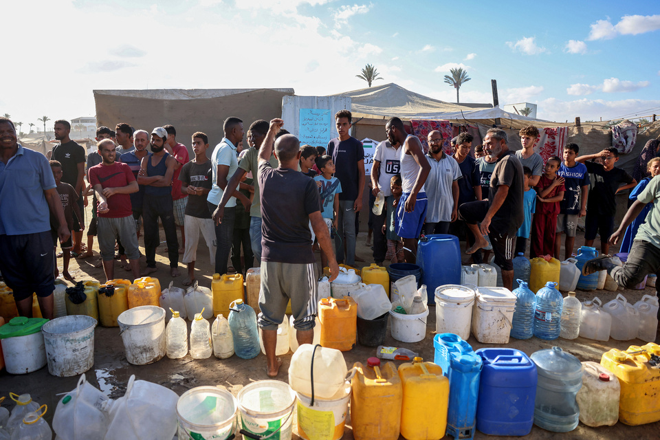 Palestinos desplazados forman fila para cargar agua en Gaza. (Fuente: AFP)