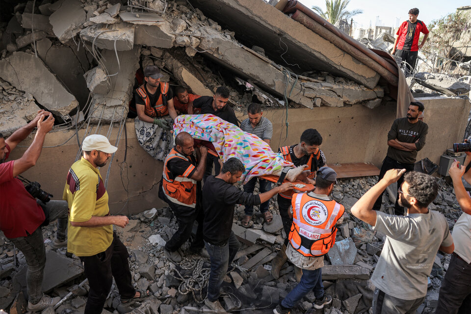 Resctistas extraen un cadaver de las ruinas de un edificio en Khan Yunis. (Fuente: AFP)