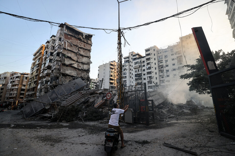 Un hombre fotografía un edificio derrumbado en un suburbio de Beirut. (Fuente: AFP)