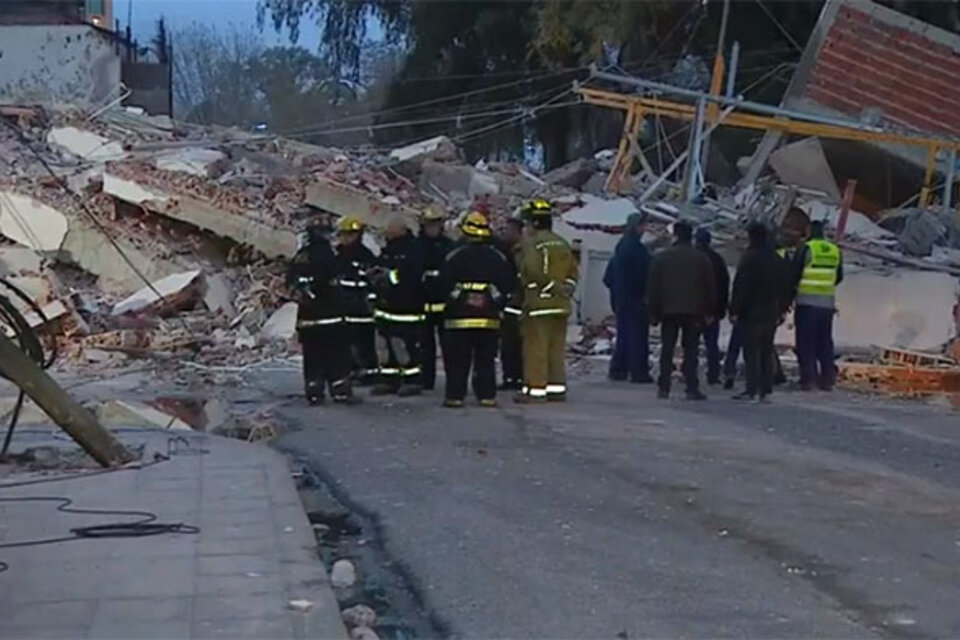 Bomberos y peritos frente a los escombros del edificio derrumbado.