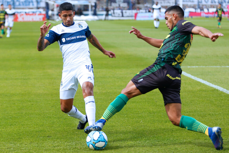 Rafael Delgado, el goleador de la tarde, lucha por la pelota frente a Matías García. (Fuente: Télam)