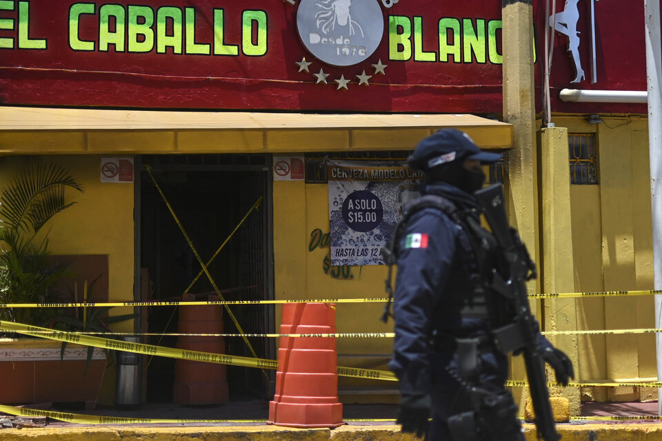 Un policía antimotines custodia el bar después de la masacre. (Fuente: AFP)