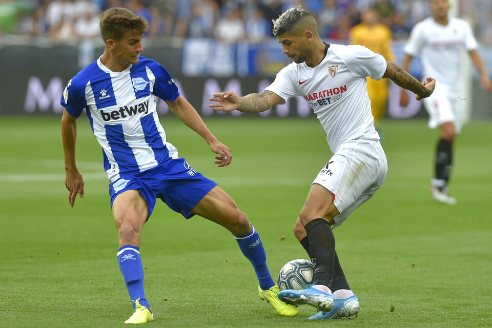 Banega maneja la pelota ante Pina. Ganó Sevilla y es el único puntero en España. (Fuente: AFP)