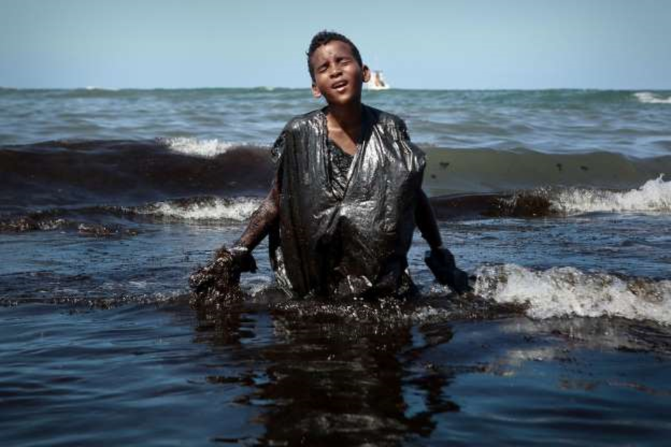El niño quería sacar el petróleo derramado en su playa en Brasil.