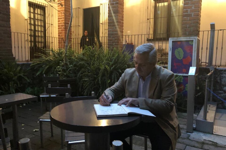 Fernández firmando el libro de visitas de la casa de Frida Kahlo.