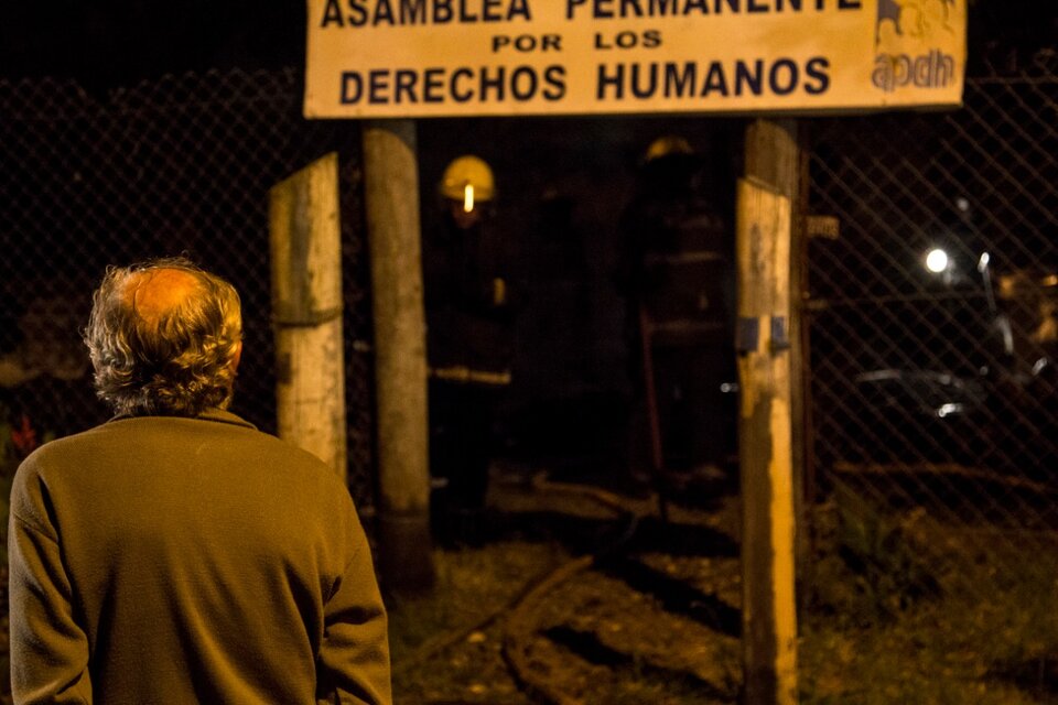 Pablo Pimentel, de espaldas, uno de los fundadores de la APDH La Matanza, observa los restos tras el incendio. (Fuente: APDH)