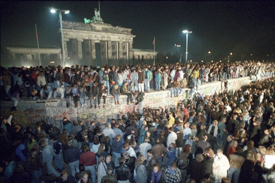 Miles de alemanes en el Muro, frente a la Puerta de Brandeburgo, la noche del 9 de noviembre de 1989. (Fuente: AFP)