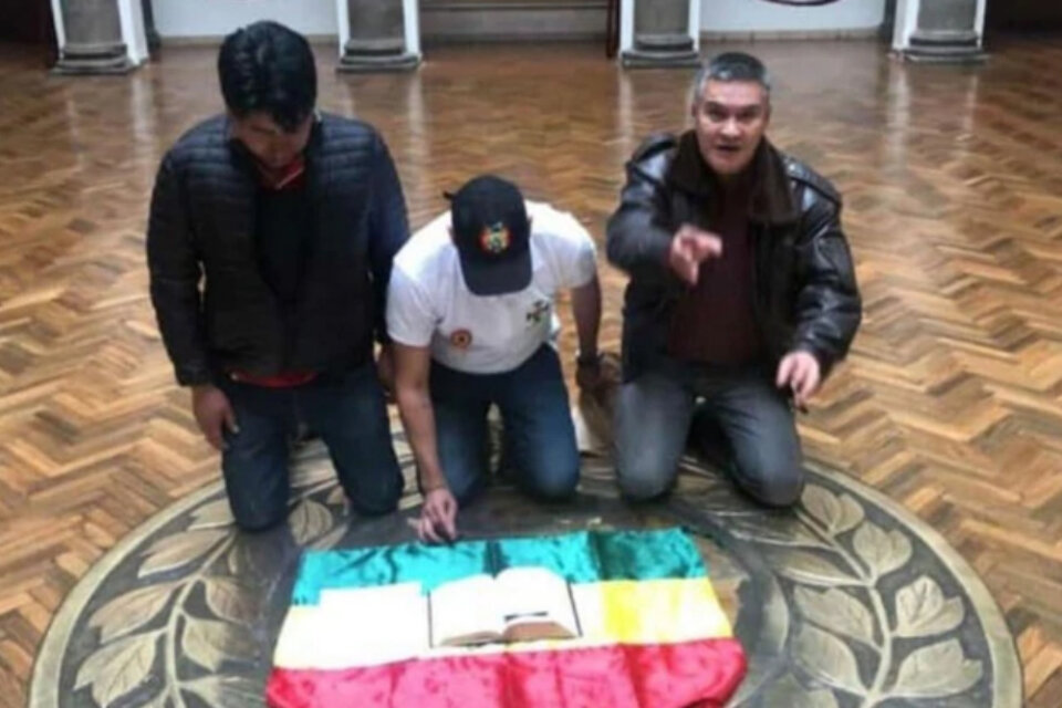 Camacho colocó su escrito sobre una biblia y la bandera boliviana arrodillándose en el piso, en la Casa de Gobierno.