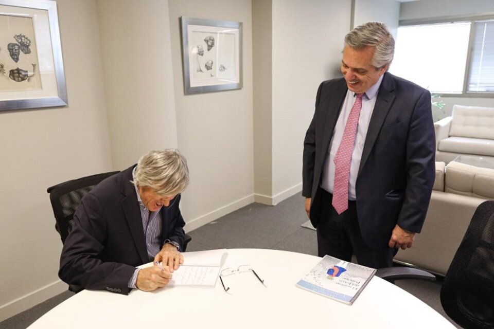 Roemmers firma un ejemplar de su novela para el nuevo presidente argentino. 