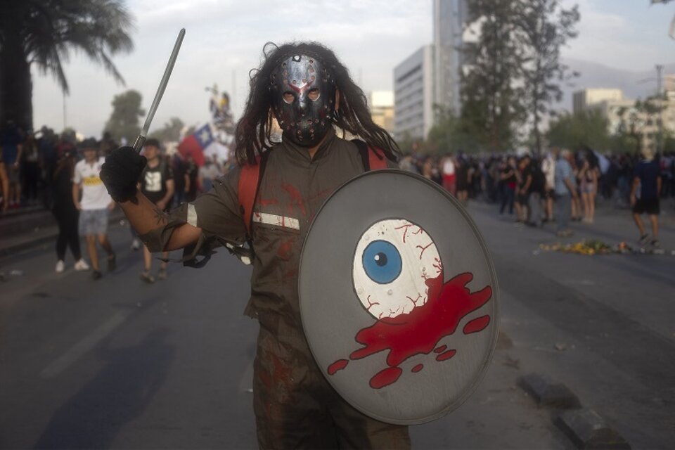 Un manifestante carga un escudo con un ojo sangrando, en una nueva marcha este viernes en Chile. (Fuente: AFP)