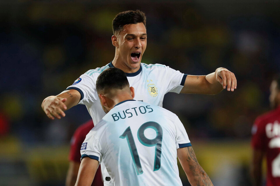 Bustos festeja con Colombo el empate. Argentina lo dio vuelta y goleó 4-1 a Venezuela. (Fuente: EFE)