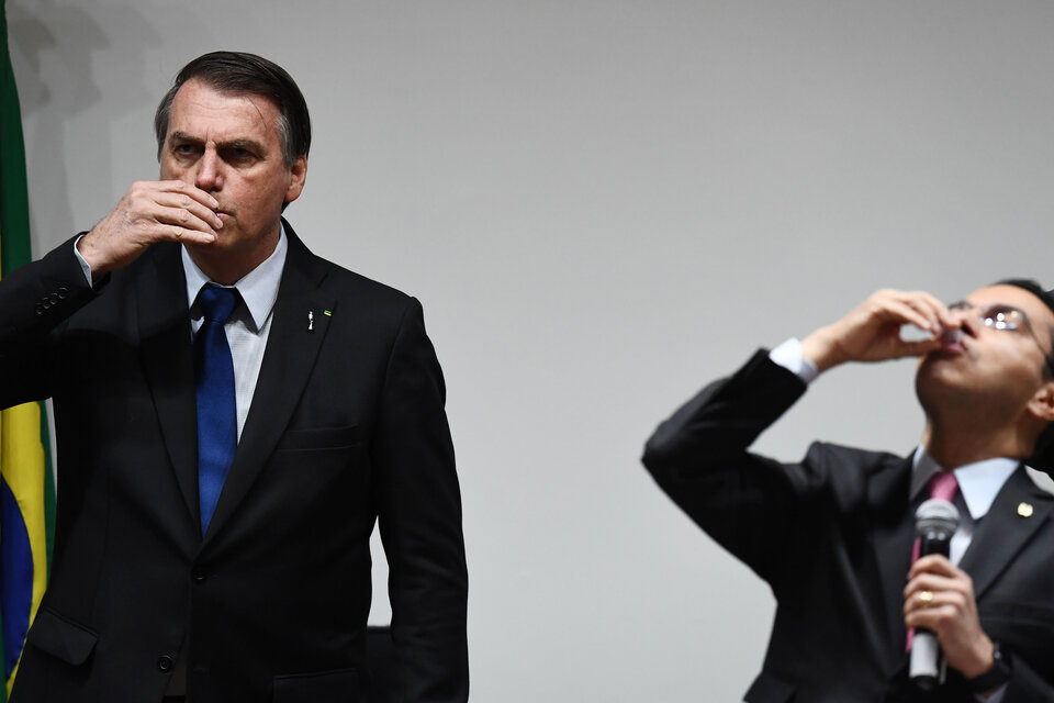 Bolsonaro bebe vino durante la ceremonia religiosa. (Fuente: AFP)
