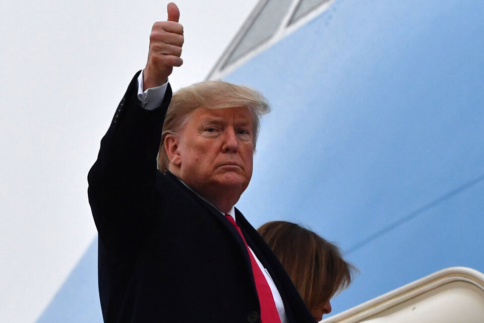 Trump saluda antes de subirse al avión presidencial rumbo a Palm Beach a pasar el fiun de semana. (Fuente: AFP)