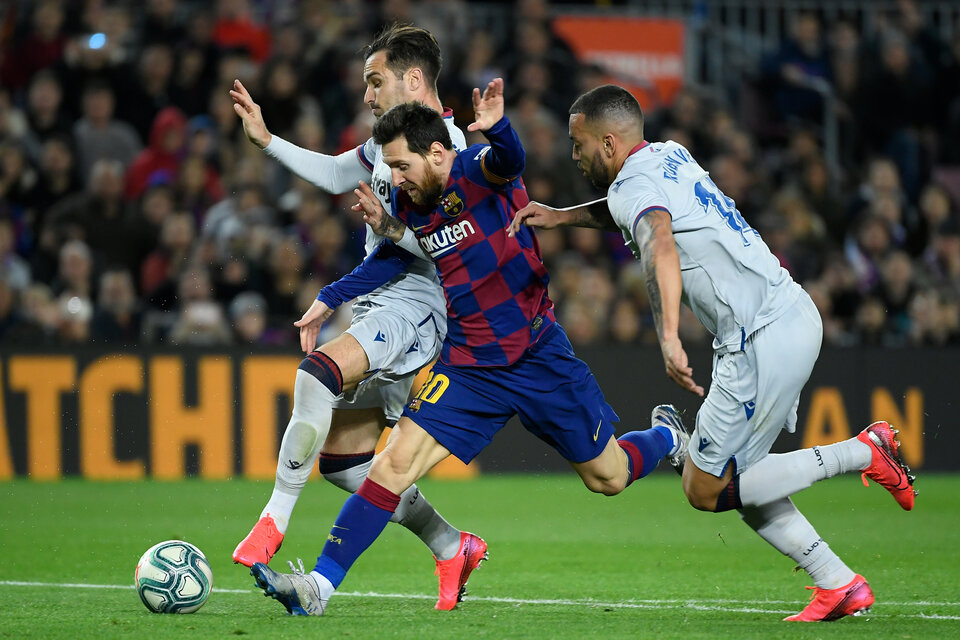 Messi pelea la pelota ante dos hombres del Levante. El Barça volvió a ganar. (Fuente: AFP)