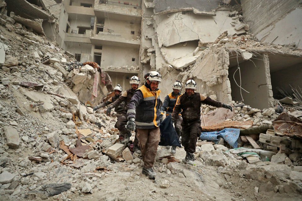 Rescatistas remueven un cuerpo de un edificio bombardeado en el pueblo de Ariha, provincia de Idlib. (Fuente: AFP)