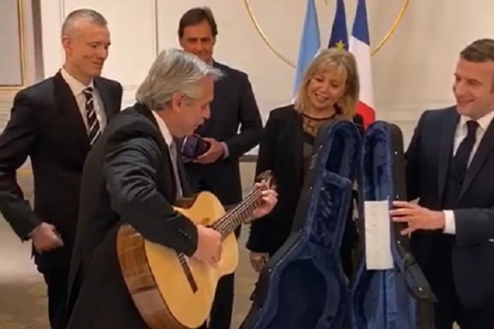 Fernández prueba la guitarra que le regaló Macron.  (Fuente: Captura de pantalla)