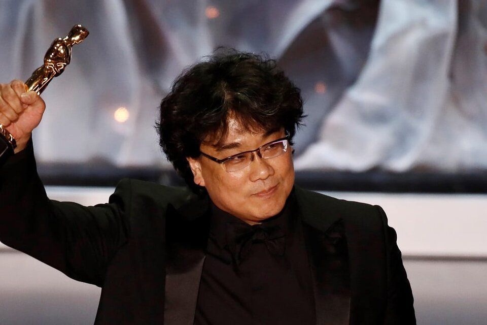Bong levanta su puño en alto, aferrando uno de sus cuatro premios Oscar.