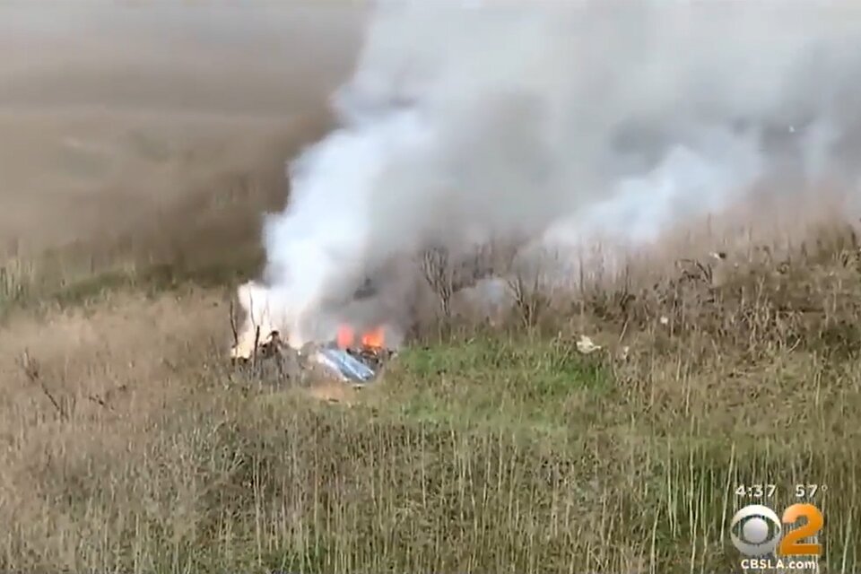 Los restos del helicóptero en el que viajaba Bryant, envueltos en llamas y una densa humareda.  (Fuente: Captura de TV)