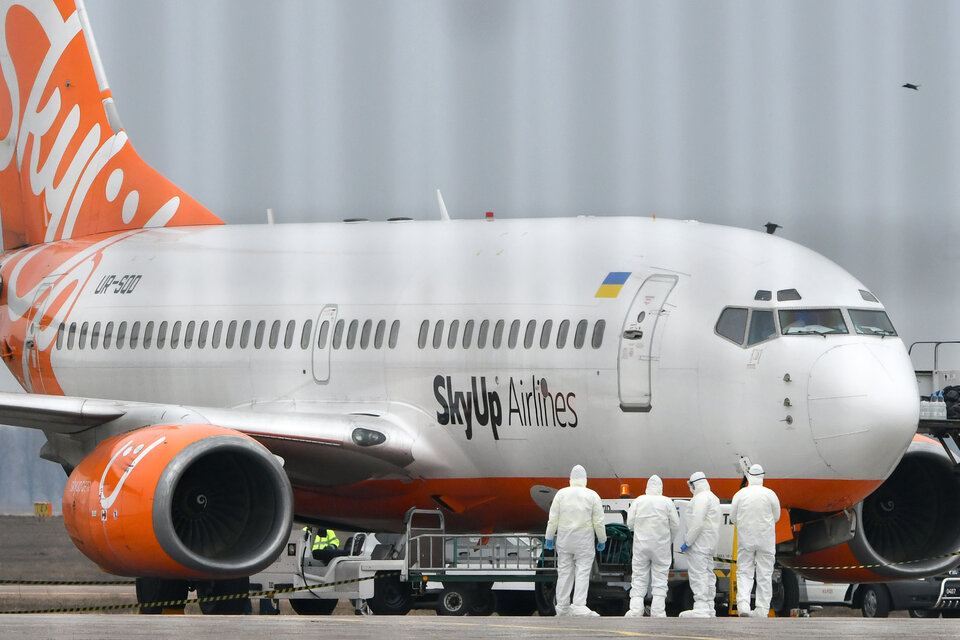 El avión que trasladó a los argentinos y el protocolo específico para recibirlos. (Fuente: AFP)