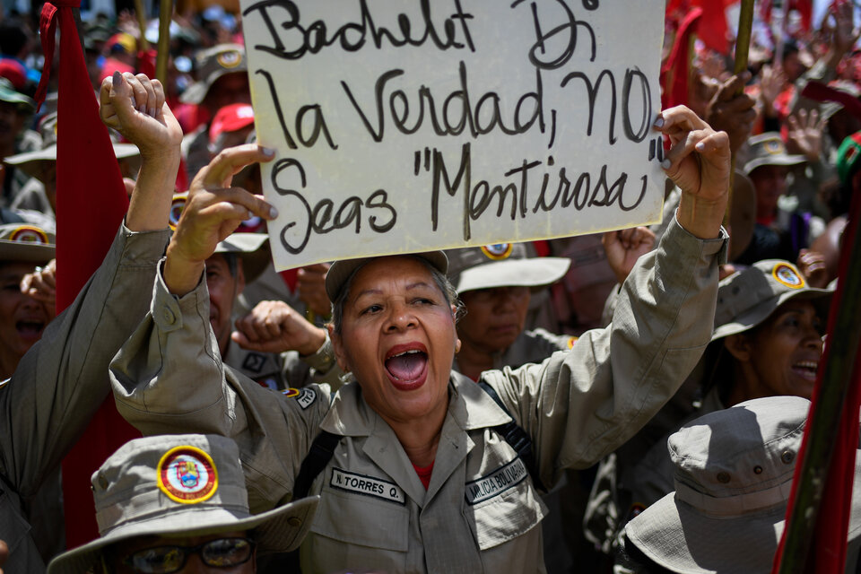 Ua integrante de la milicia bolivariana sostiene un cartel criticando a Bachelet en la marcha de hoy en Caracas (Fuente: AFP)