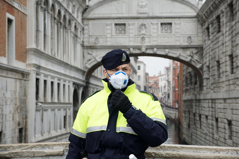 Un policía con barbijo monta guardia antes de la suspensión del carnaval en Venecia. (Fuente: EFE)