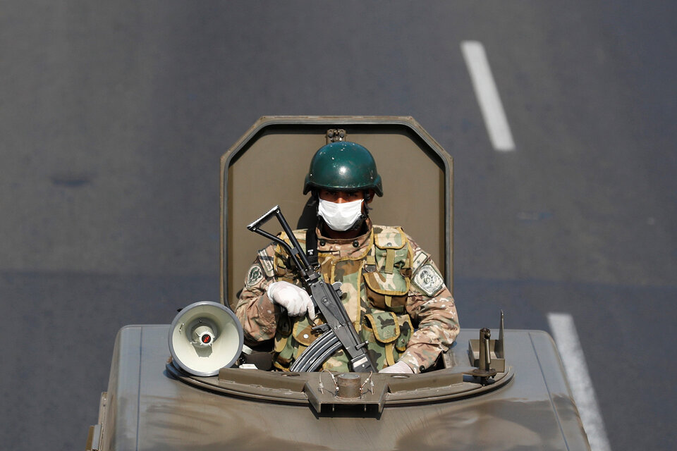 Un militar peruano patrulla las calles de Lima con barbijo, autoparlante y fusil automático.  (Fuente: EFE)