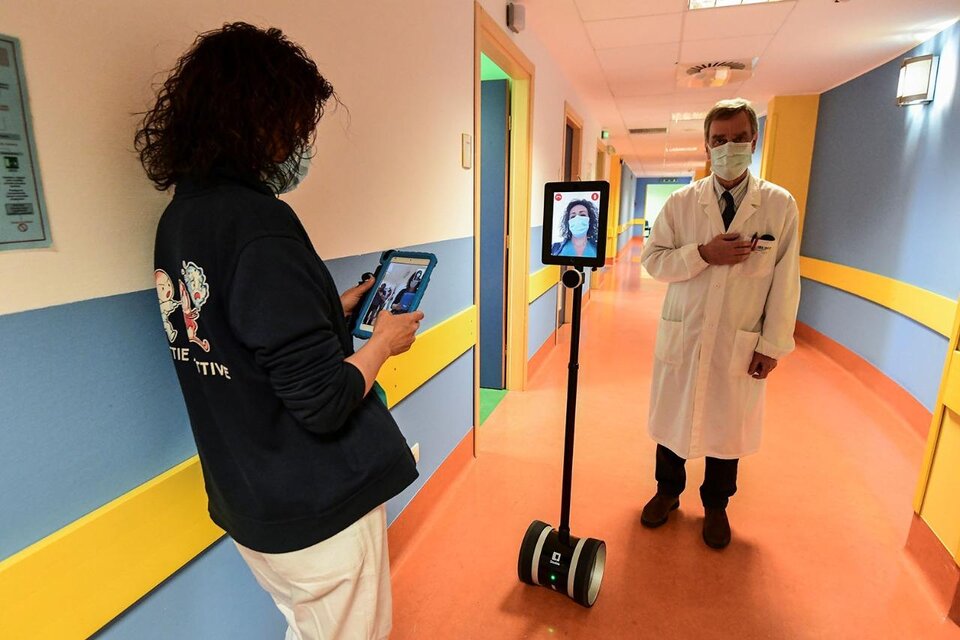 Una enfermera manipula un robot que ayuda a pacientes de coronavirus en un hospital de Varese, Italia. (Fuente: AFP)